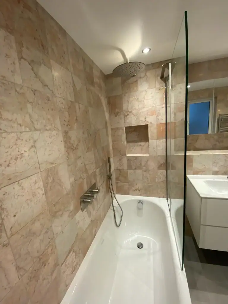 Detailed view of high-gloss white double-drawer vanity basin, single chrome lever faucet, and overhead mirrored cabinet with integrated lighting in a renovated Dulwich bathroom