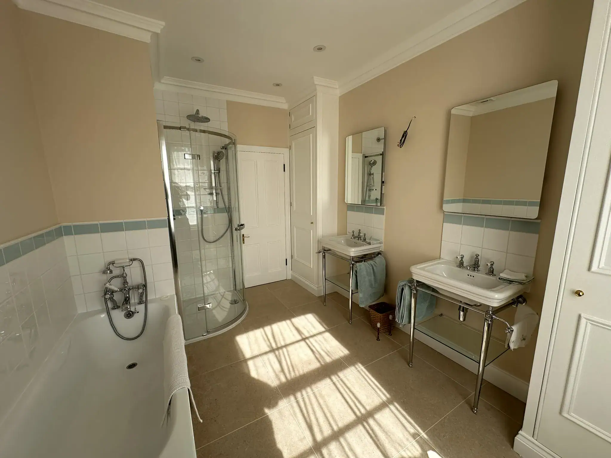 Traditional inset bath and curved glass shower beneath original coving in Pimlico