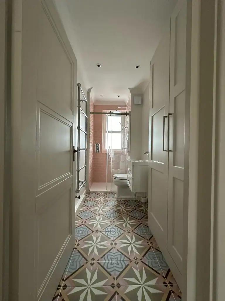 Sliding glass shower with pink subway tiles and chrome rainfall head in Clapham
